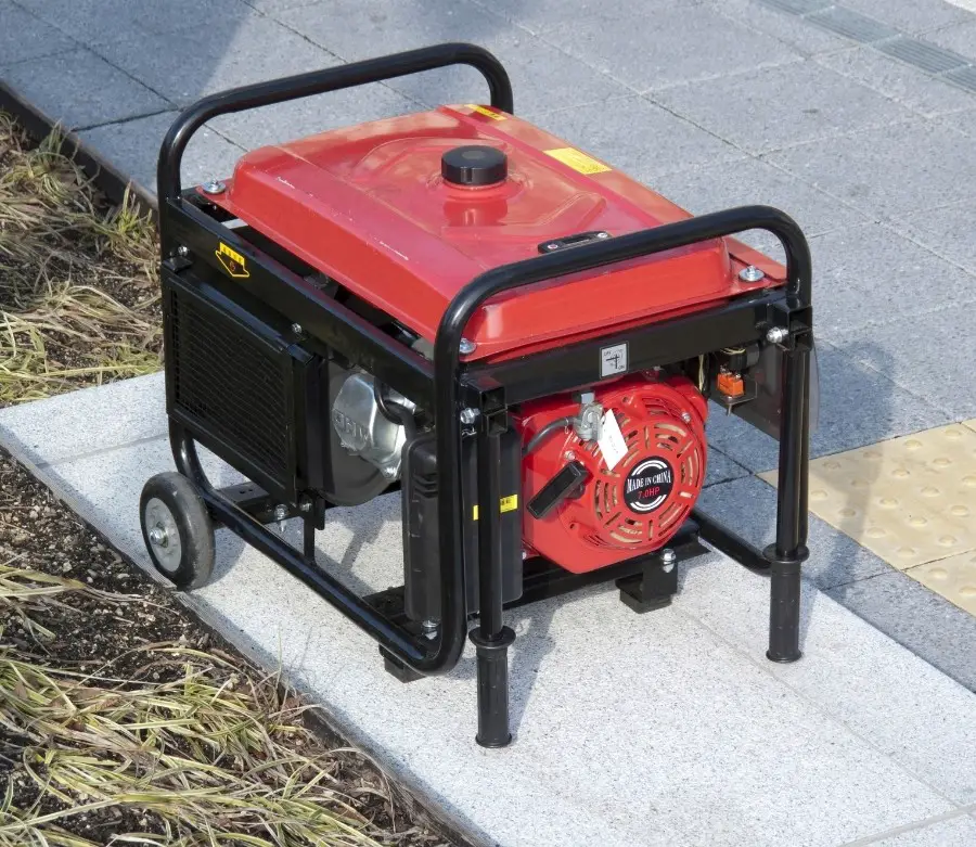 A red portable generator on a patio step.